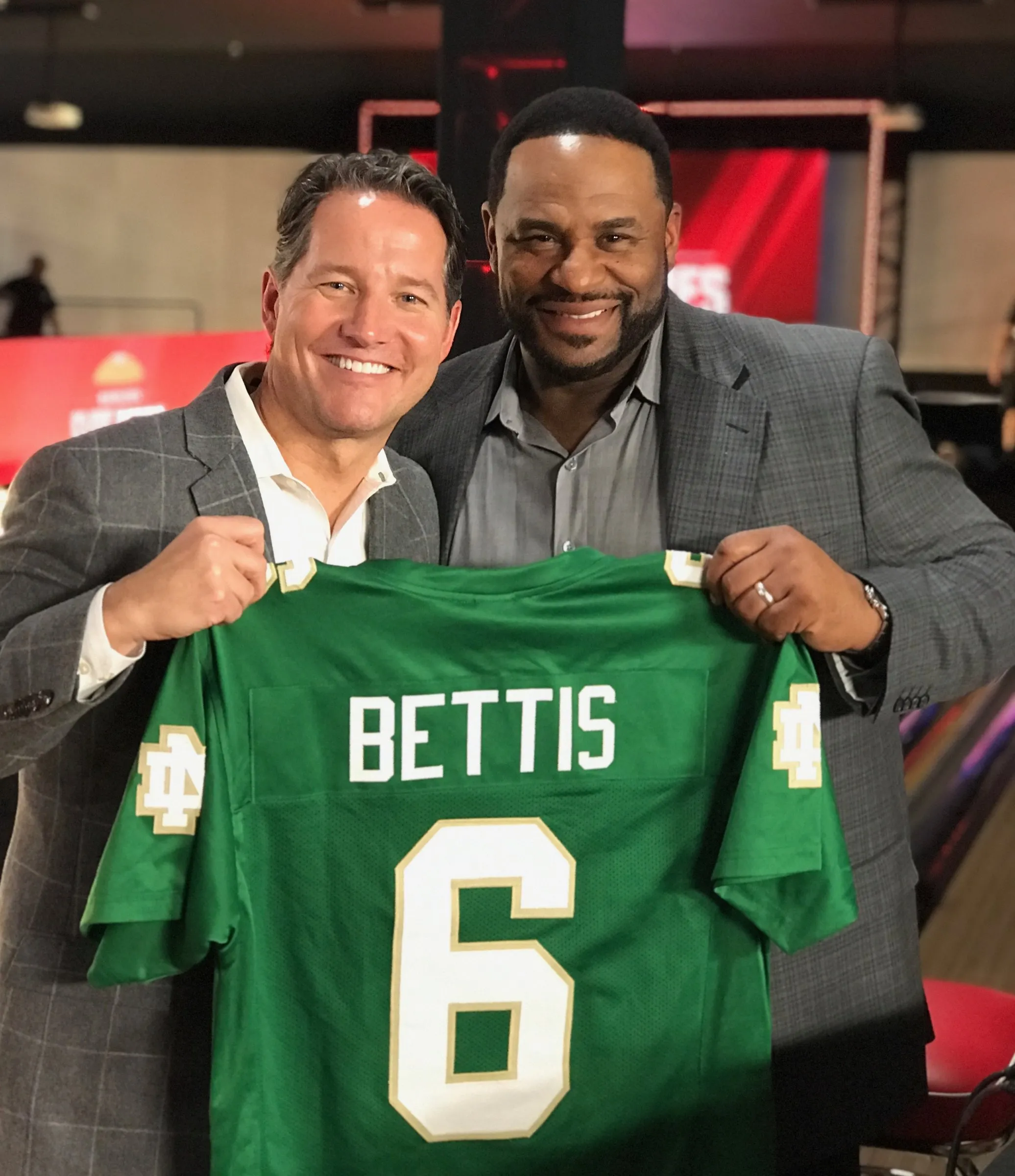 Todd Harris holding a number six Bettis jersey alongside Jerome Bettis.