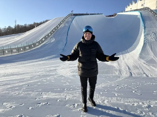 Todd Harris with his arms out at the bottom of an empty halfpipe on a bright morning.