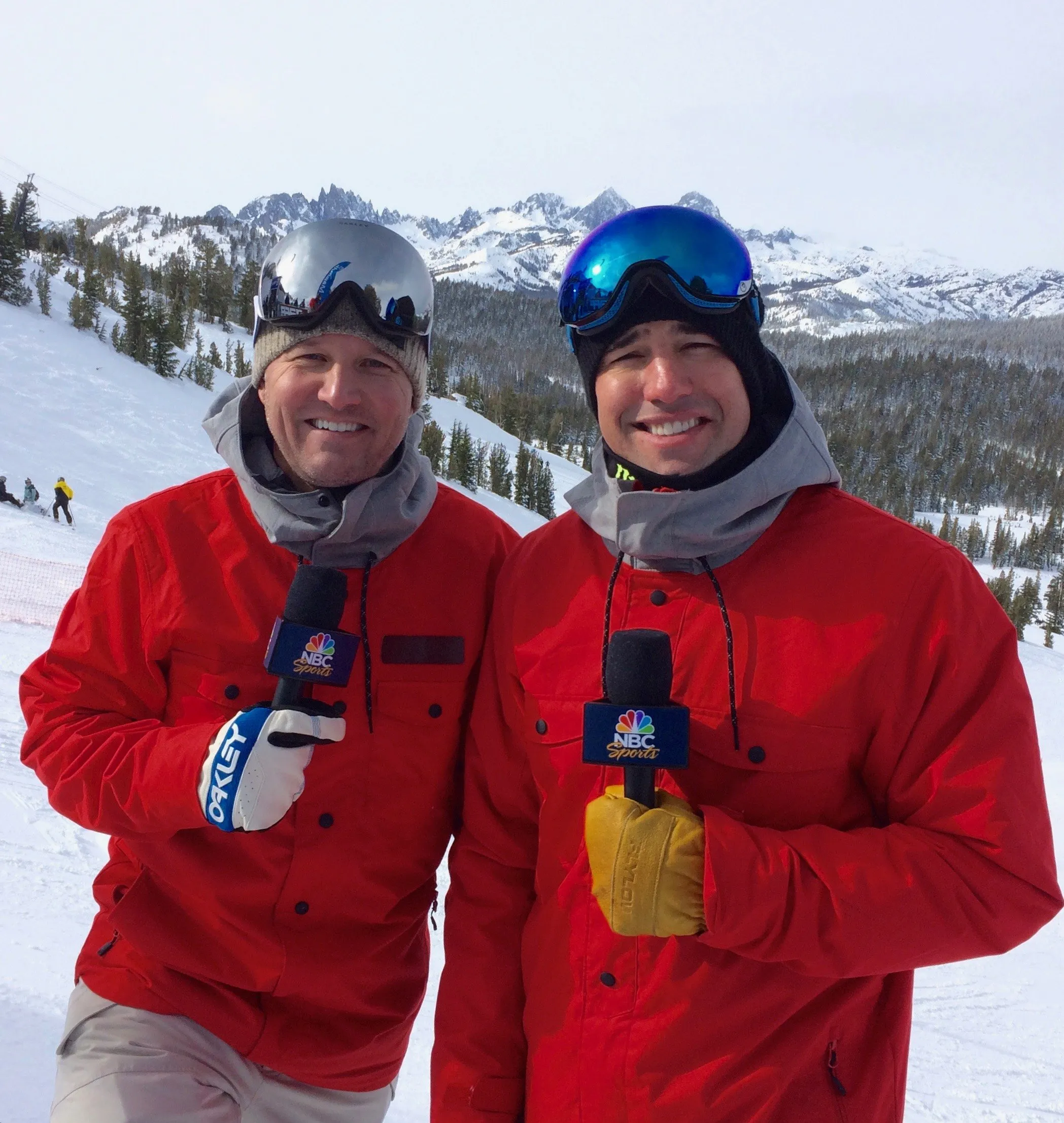 Todd Harris and a colleague in matching red jackets and goggles on the snow.
