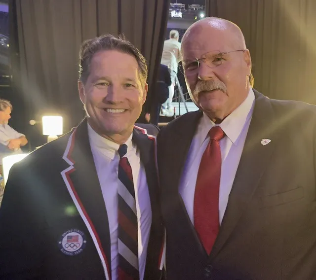 Todd Harris in a blazer and pin beside a colleague at an evening event.