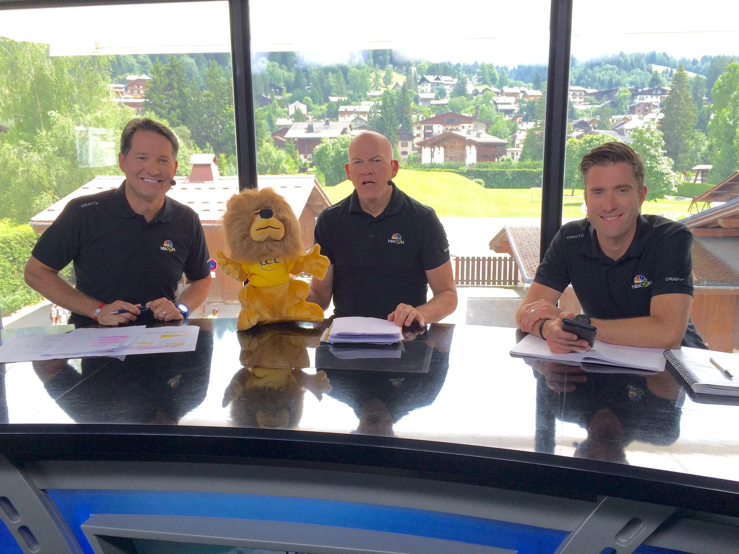 Todd Harris at an outdoor commentary desk on the Tour de France.